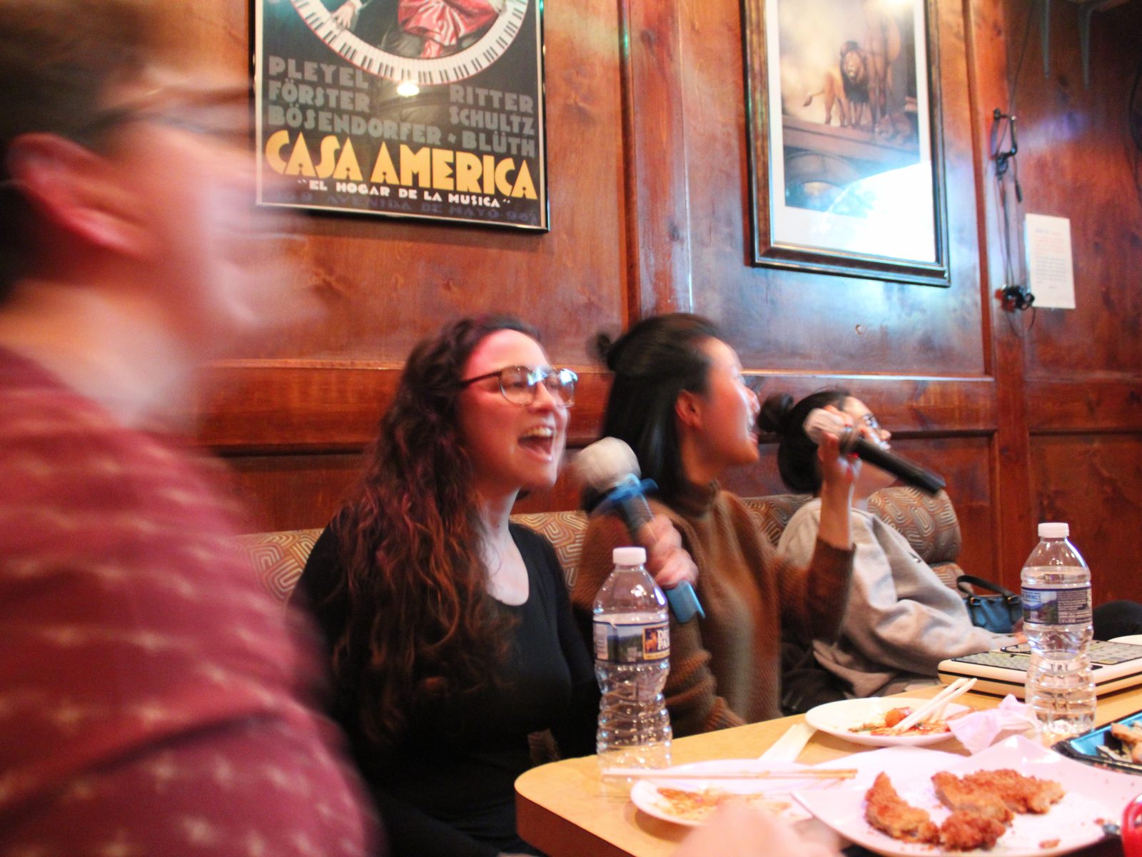 Three Motivf team members singing into microphones at a karaoke event.